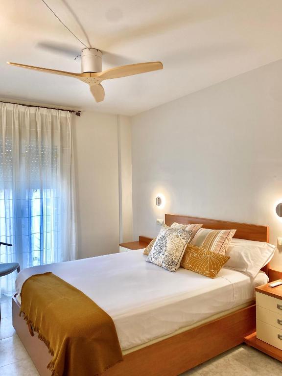 a bedroom with a large bed with a ceiling fan at Apartament Natura amb Calma in Olot
