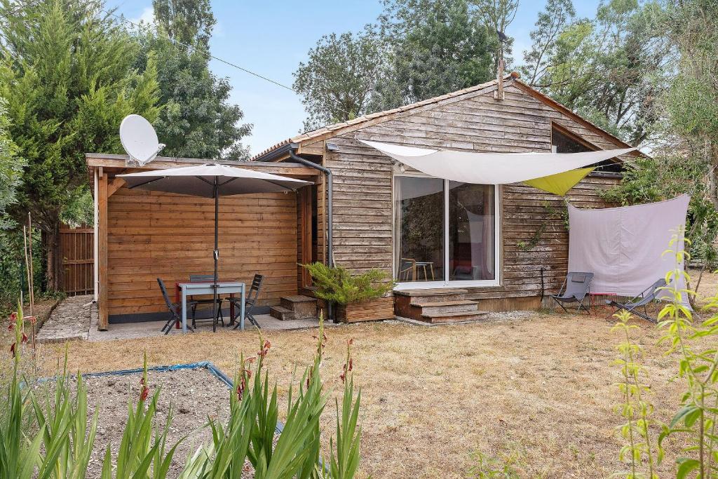 a small house with an umbrella and a table and an umbrella at Chalet Studio Athome in Bouhet