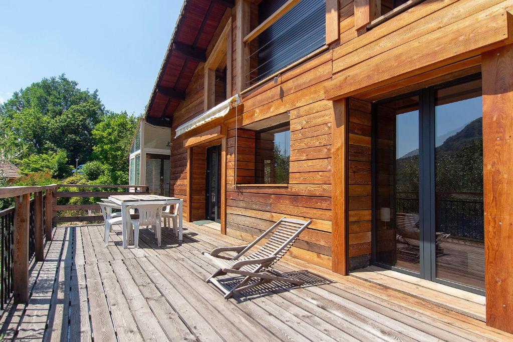 a wooden deck with a table and chairs on it at Gite Les Grillons in Belvédère