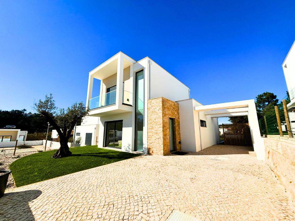 a white house with a driveway in front of it at Casa da Lagoa - By SCH in Foz do Arelho