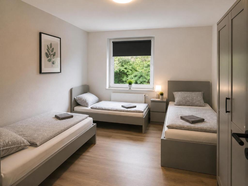 a room with two beds and a window at Pulheim Room in Pulheim