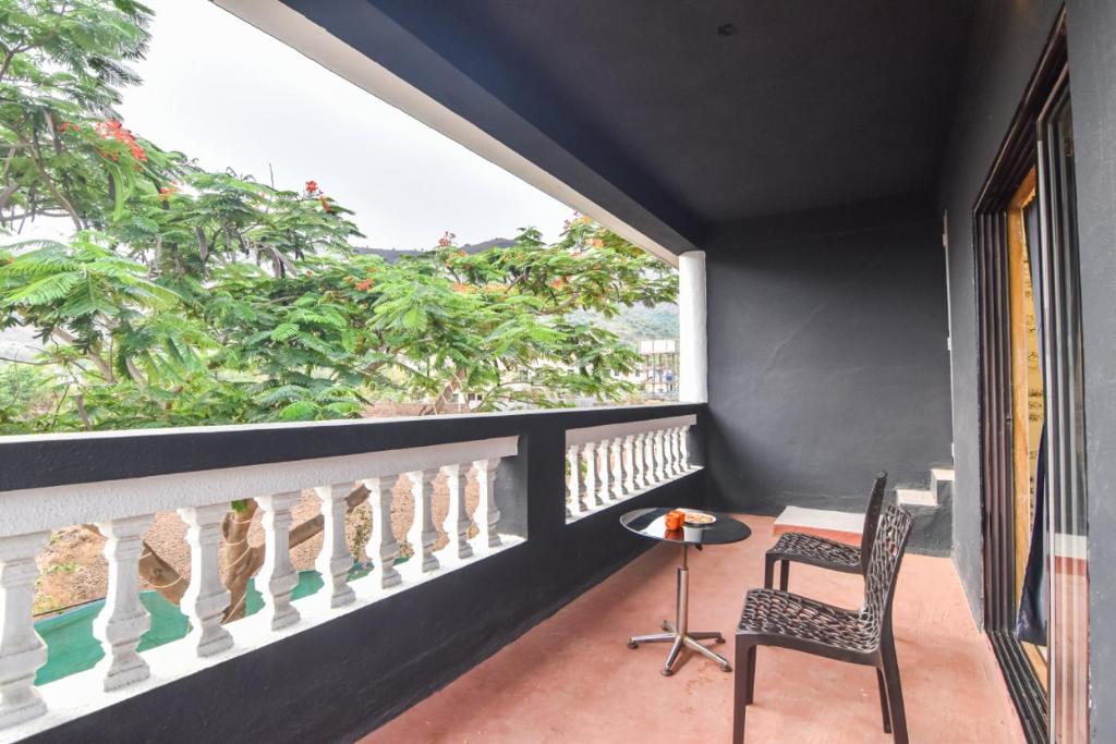 a balcony with a table and a chair and a window at II BLACK JAGUAR II 3BHK II AC II PRIVATE POOL Il in Lonavala
