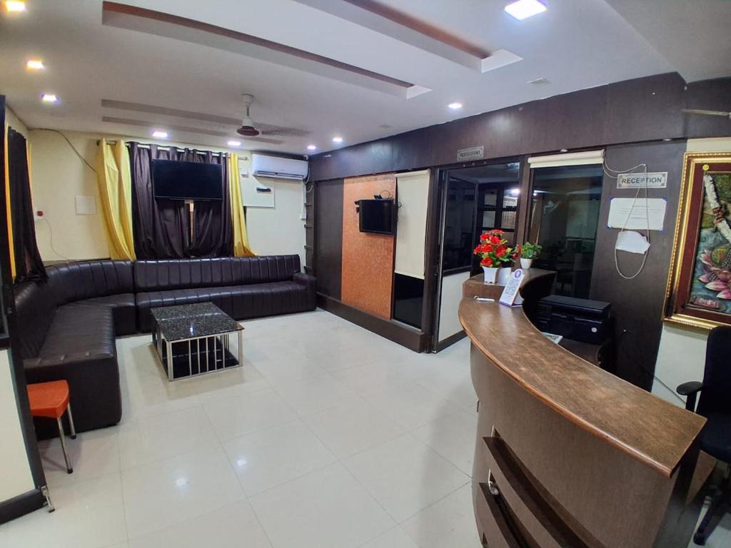 a living room with a couch and a bar at Hotel 9 square in Shamshabad