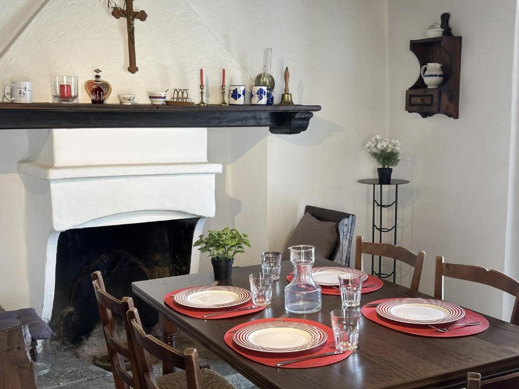 a table with plates and glasses on it with a fireplace at Al Torchio by Fewotessin in Riazzino