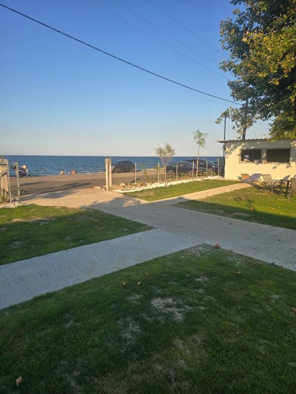a sidewalk leading to a beach with the ocean in the background at Krikonis Apartments Leptokarya in Leptokarya