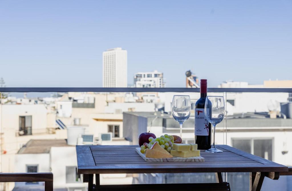 a table with a bottle of wine and a glass at St Julians`s Charm Apartments in Is-Swieqi