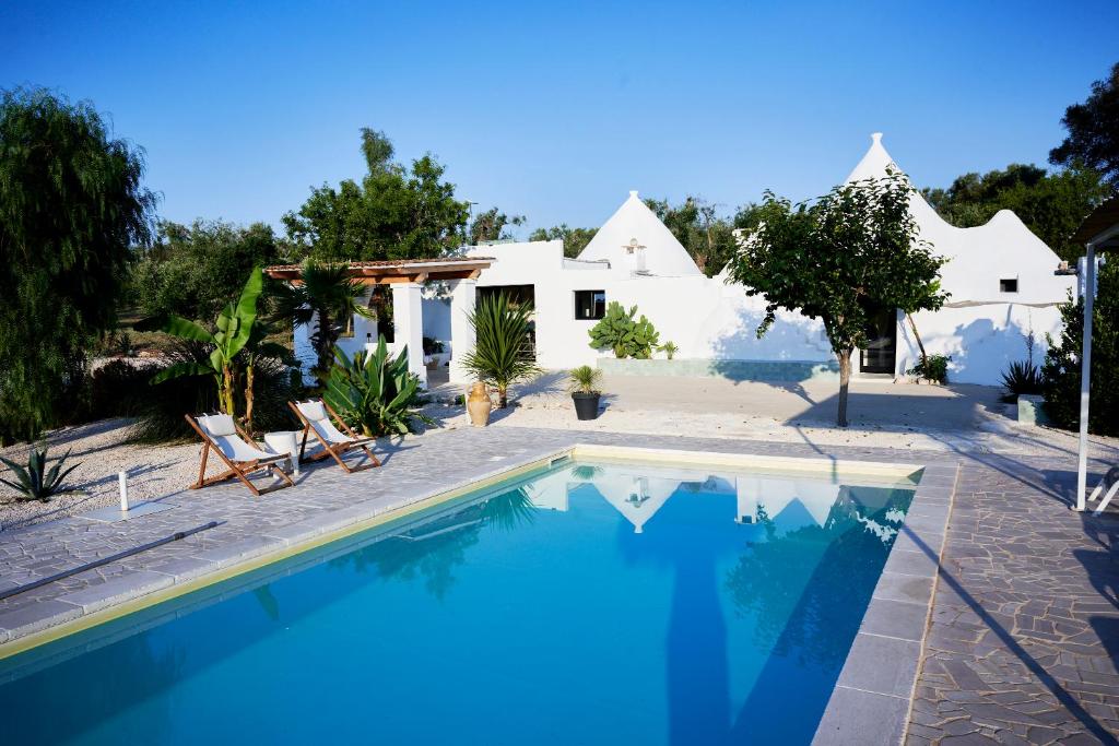 a villa with a swimming pool and a house at Trullo KAVA - Ceglie Messapica in Ceglie Messapica