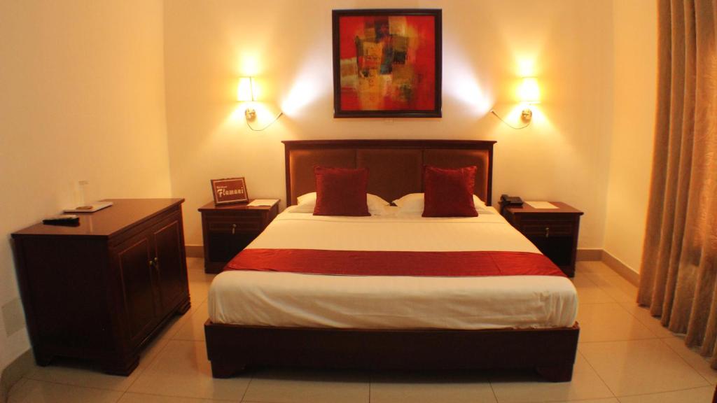 ein Hotelzimmer mit einem Bett und zwei Nachttischen in der Unterkunft Hotel Residence Flamani in Lomé
