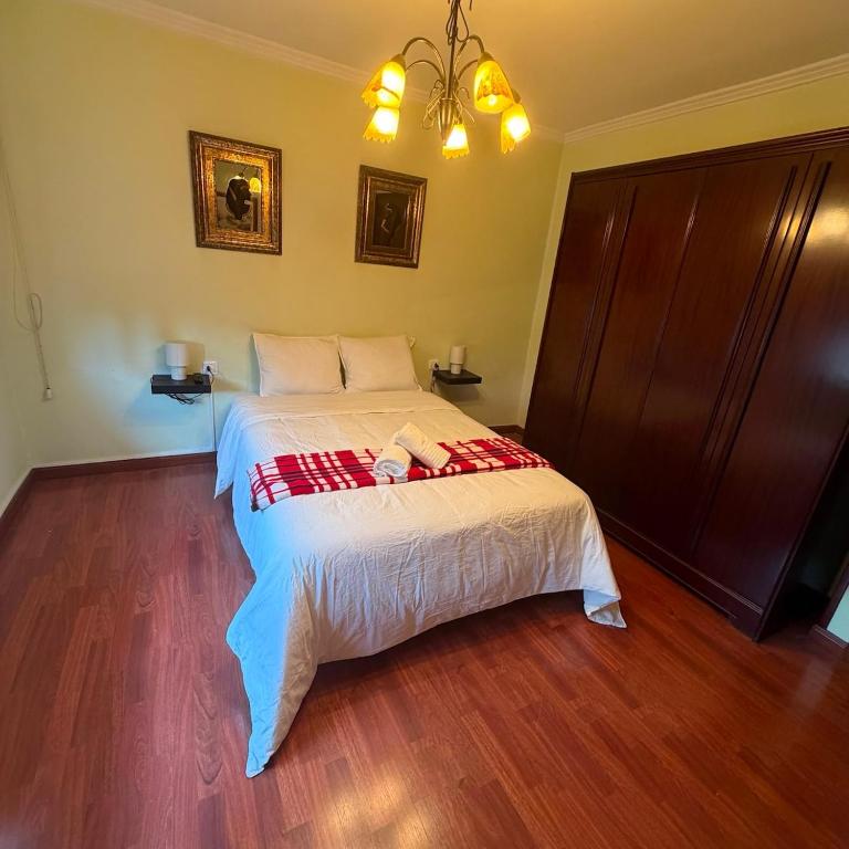 a bedroom with a bed with a red and white blanket at Casa dos avós in Redondela