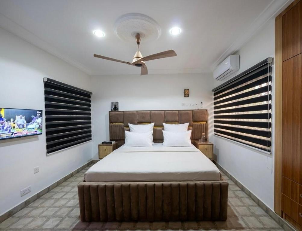 a bedroom with a bed and a ceiling fan at Paradise Creek Hotel in Tamale