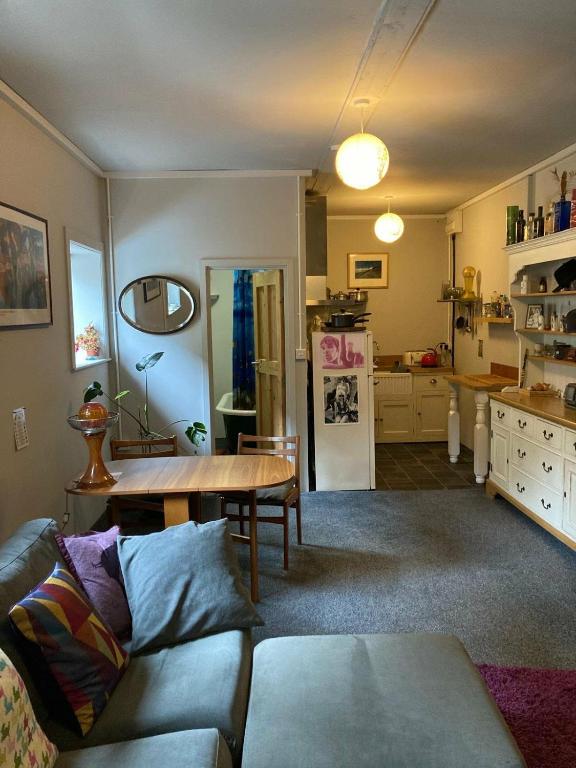 a living room with a couch and a table at Step-free modern central apartment in Todmorden