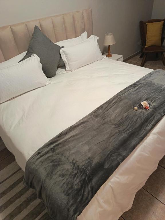 a large bed with a black and white comforter at Serendipity Guest House in Richards Bay