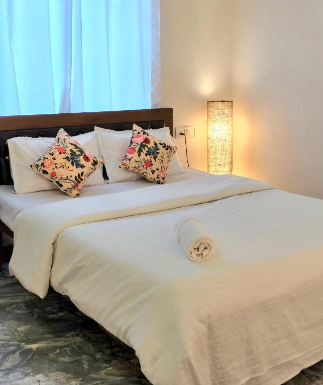 a large white bed with pillows on top of it at Daffodil in Anjuna