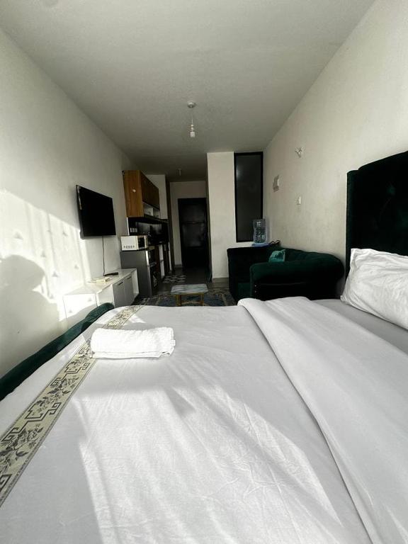 a large white bed in a room with a living room at Tsavo in Nairobi