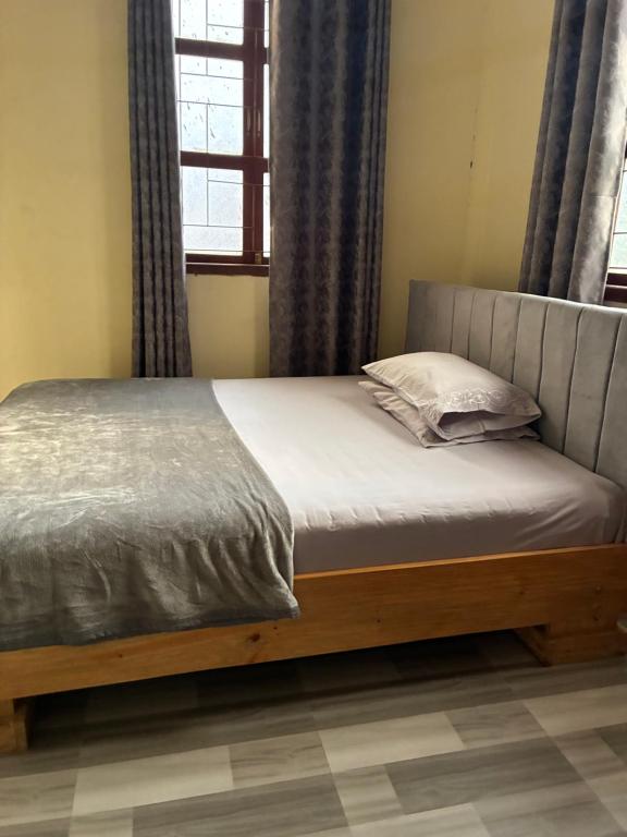 a bed sitting in a room with a window at Hakuna matata Apartments in Zanzibar City