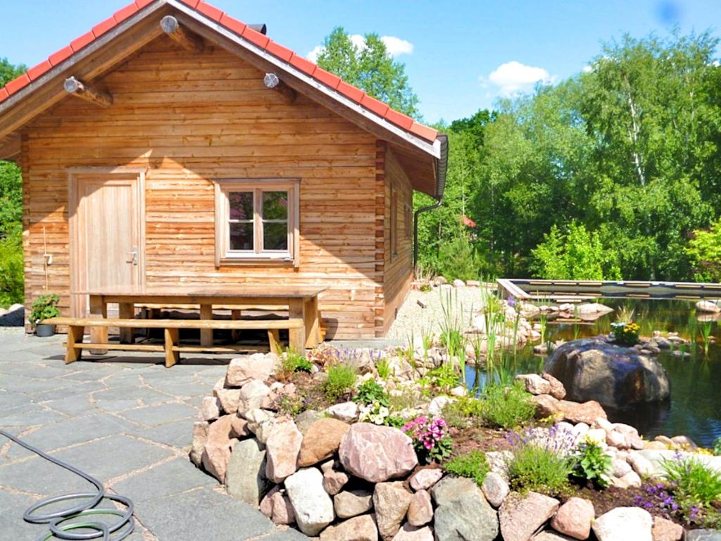 a log cabin with a pond and a garden at Fjällstugan in Sund