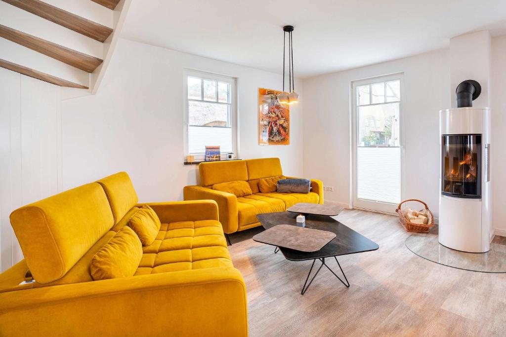 a living room with a yellow couch and a fireplace at Ferienhaus Baltic Huus in Zirchow