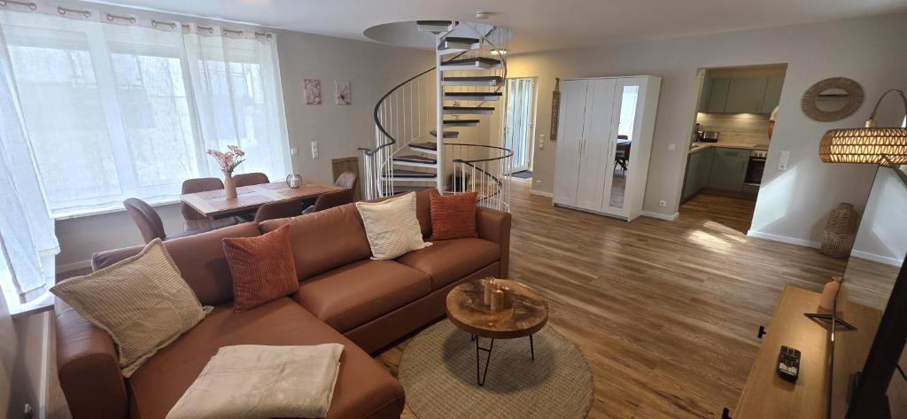 a living room with a brown couch and a table at White Coast Villa in Grömitz