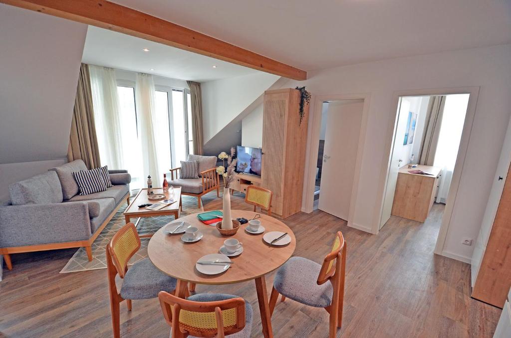 a living room with a table and chairs at Am Ufer Top 13 in Dranske