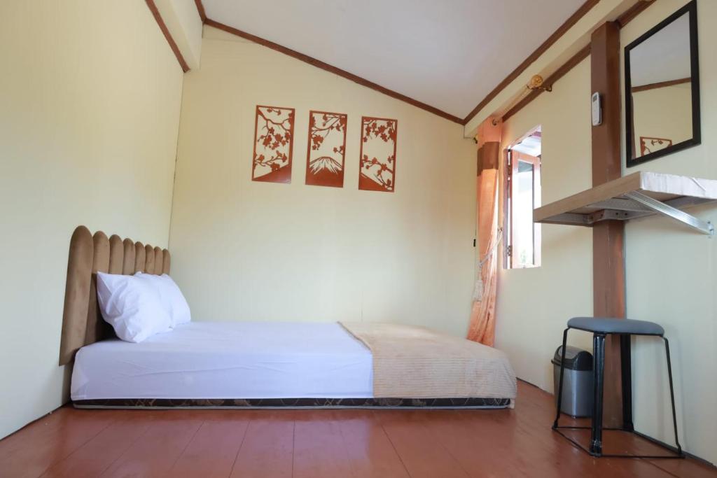 a bedroom with a bed and a chair in a room at Ghaniya Homestay in Bonto