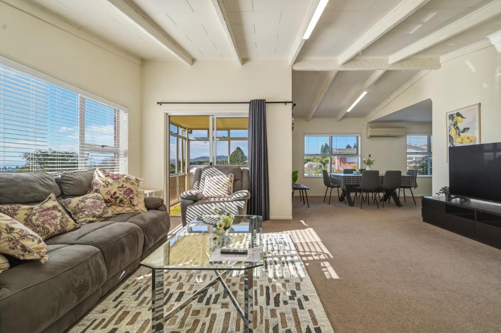 a living room with a couch and a tv at Springfield bliss with Lake view in Rotorua