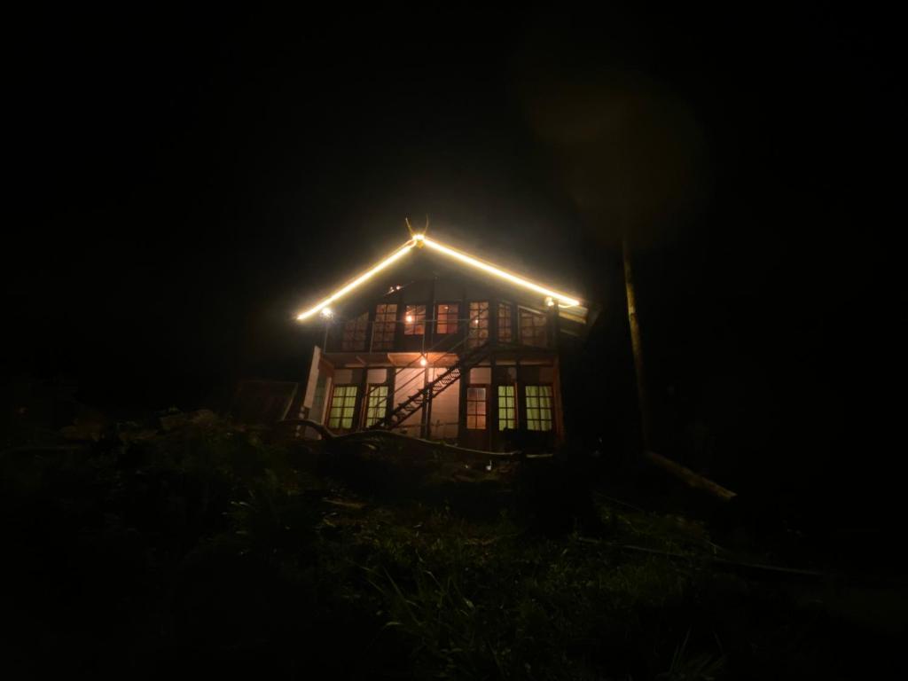 a house with lights on the roof at night at Aradya eco resort in Pundaluoya