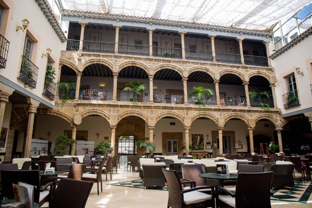 an empty courtyard with tables and chairs in a building at Palacio de los Velada in Avila