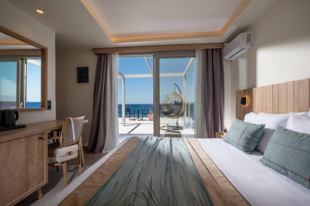 a bedroom with a bed with a desk and a balcony at San Marine Beach Hotel, Heart of Chersonissos, Steps from the Sea in Hersonissos