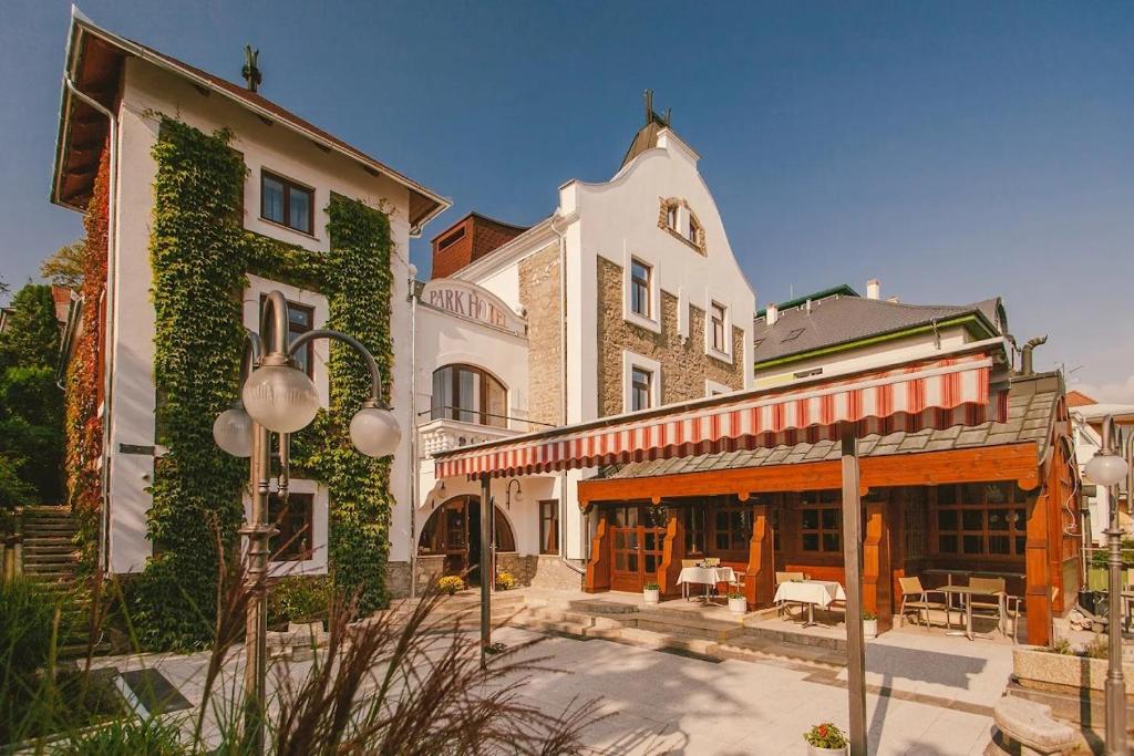 a large white building with ivy growing on it at Park Hotel in Hévíz