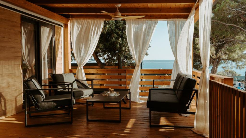 a screened in porch with chairs and a table at Val Lodge Šimuni in Šimuni