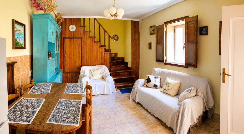 a living room with a table and a couch at O recuncho - Alojamiento tranquilo cerca de Ribeira Sacra y Ourense in Maceda