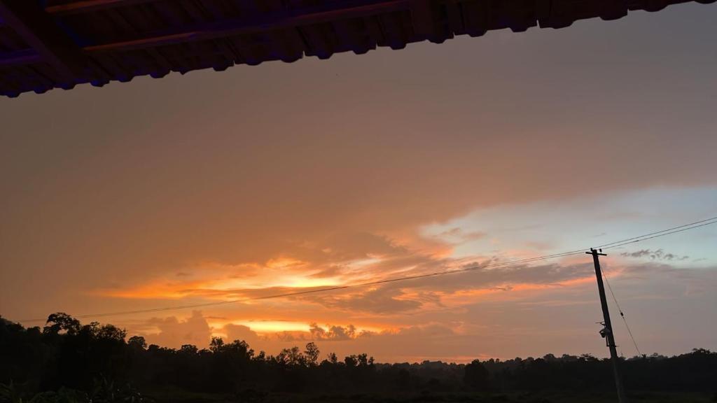 a sunset is seen through the window of a house at Misty field view Homestay in Ponnampet