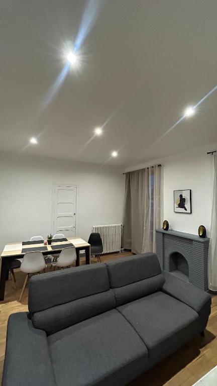 a living room with a couch and a table at Victor Hugo's Le Central in Saint-Junien