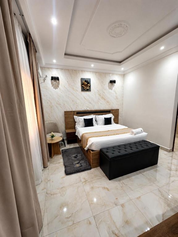a bedroom with a large bed and a couch in it at Hôtel La Miséricorde in Douala