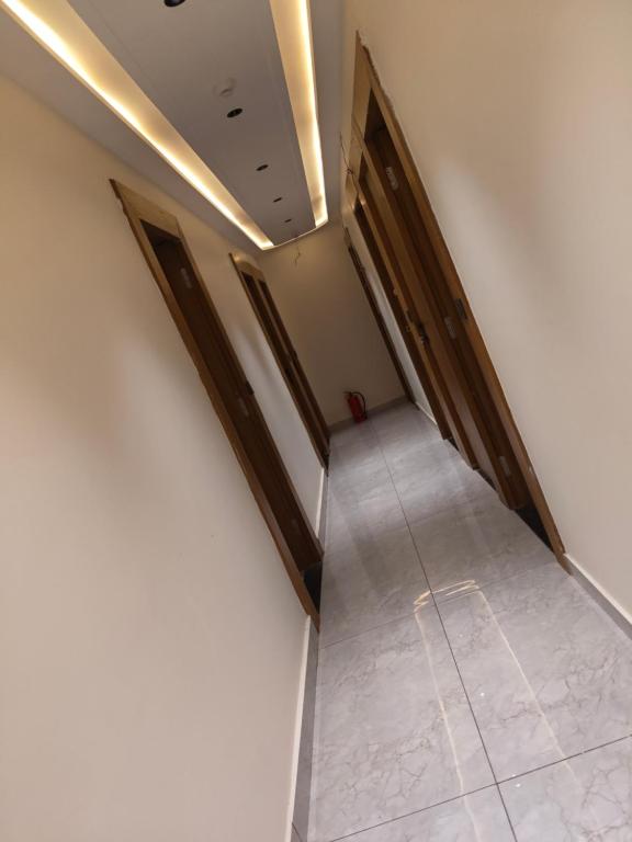 an empty hallway with wooden doors and a tile floor at Hotel Raddizone in Gandhinagar