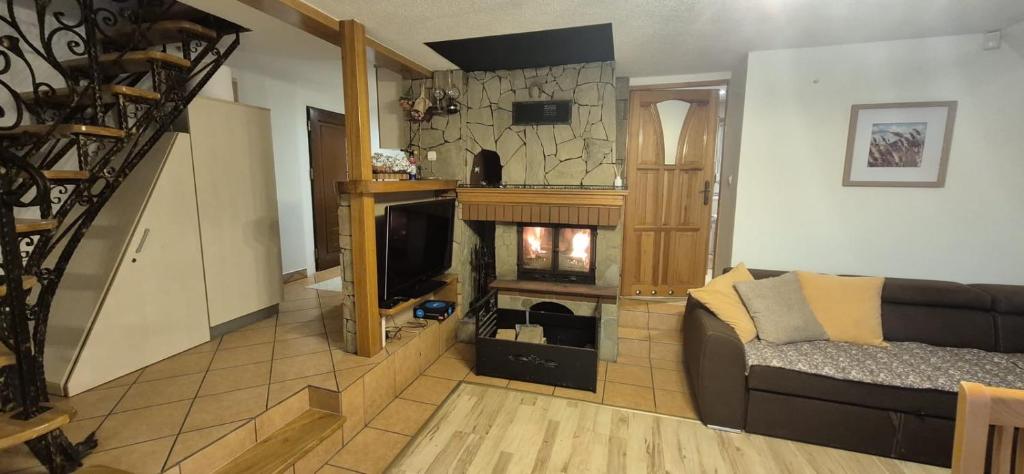 a living room with a couch and a fireplace at Leśna Przygoda ,,Balia w cenie" in Harbutowice