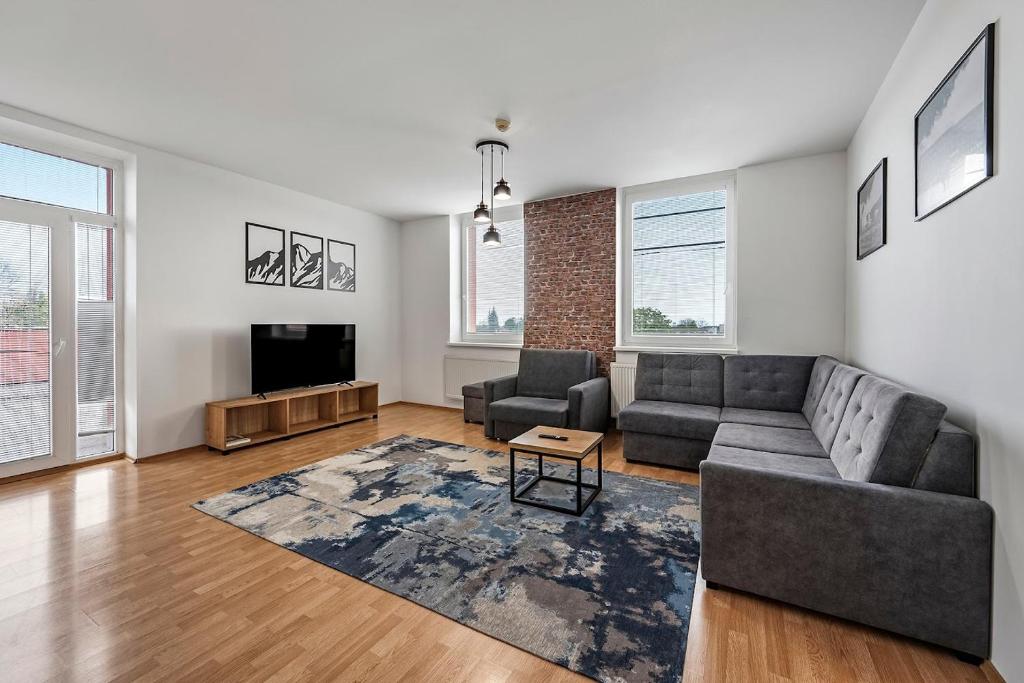 a living room with a couch and a tv at Hotel Spolcentrum in Jezersko