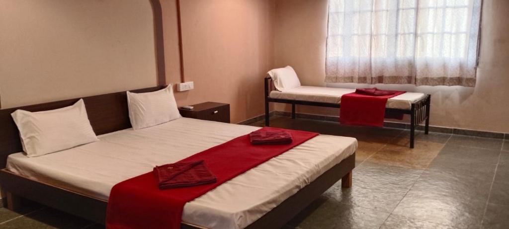 a hotel room with two beds and a chair at Minakshi Resort in Loni Kand