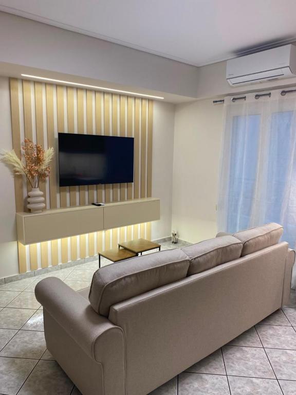 a living room with a couch and a flat screen tv at Folia City Center with Parking in Chalkida