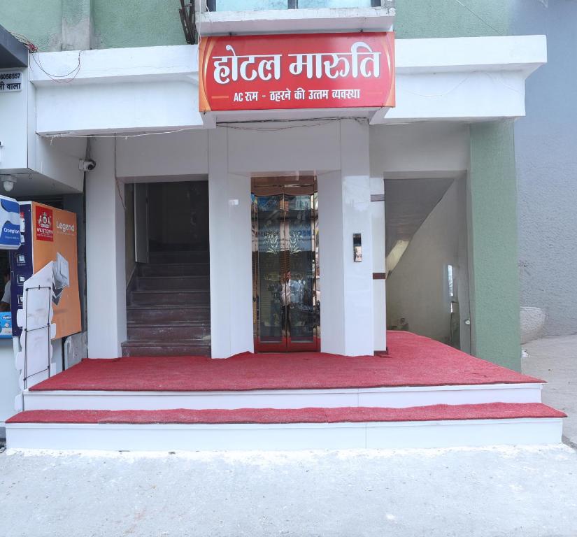 a store front with a red sign on the door at Hotel Maruti in Mandsaur