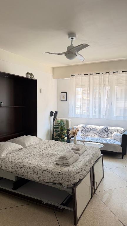 a bedroom with a large bed and a couch at Studio lumineux avec balcon à Nice in Nice