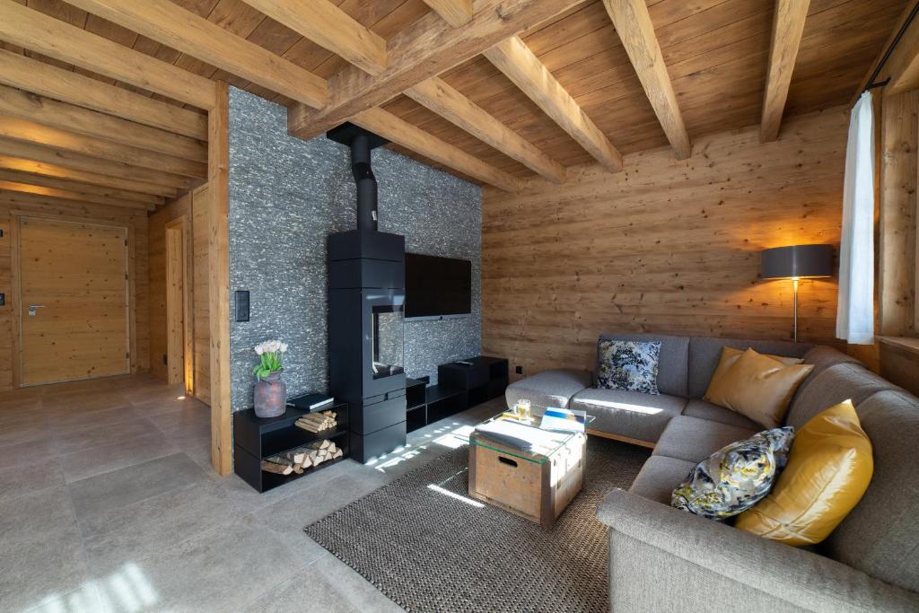 a living room with a couch and a fireplace at Chalet Frümsel - Luxury & Bergblick in Wildhaus