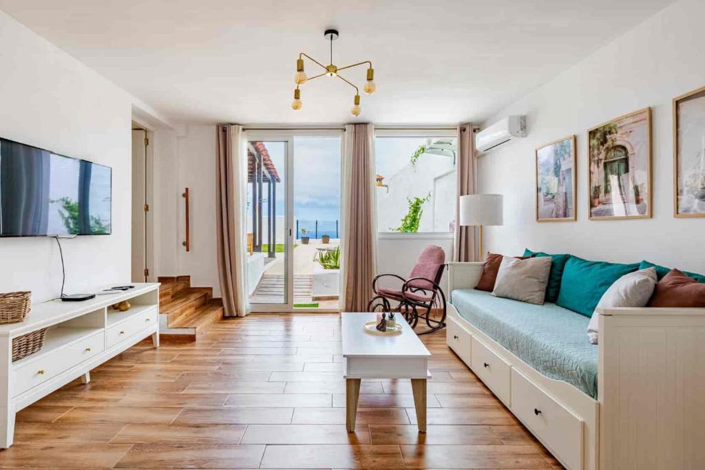a living room with a couch and a tv at Casa Teide, disfruta de el atardecer en tu gran terraza privada in Icod de los Vinos