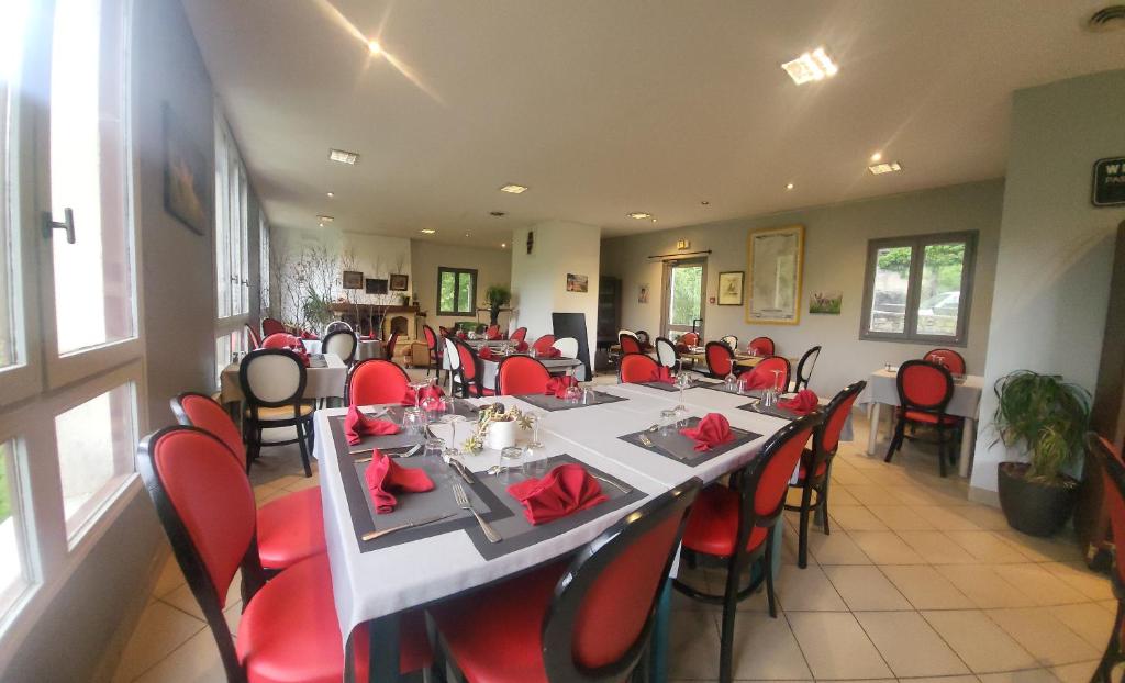 a dining room with a long table and red chairs at Auberge du Tarnon in Vébron