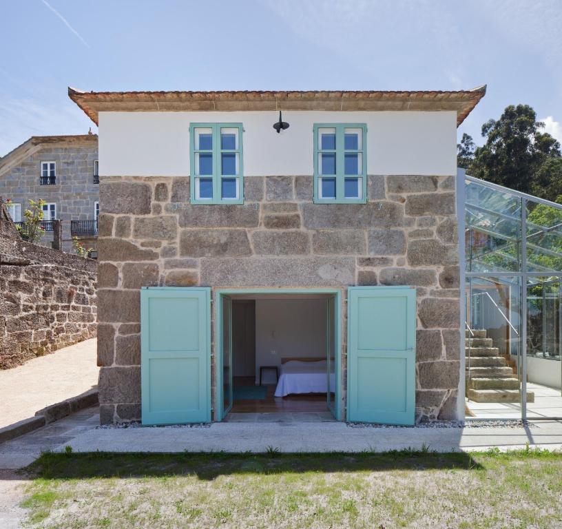 an external view of a stone house with blue doors at Casa Caseiros, Couso in Gondomar