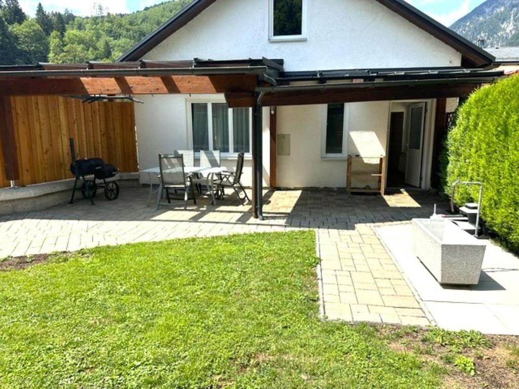 a covered patio with a table and chairs in front of a house at Ferienapartments 31erHaus in Hieflau
