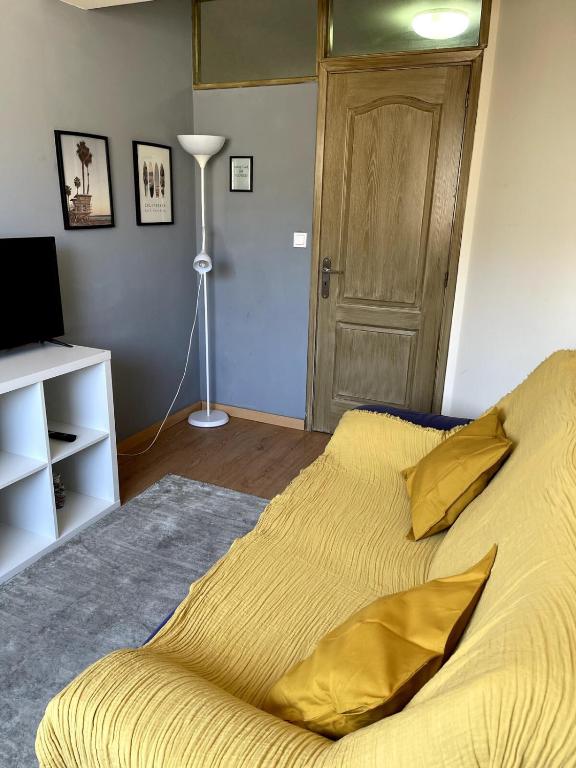 a bed with a yellow comforter in a bedroom at Flat with nice view in Gualtar, Braga in Braga