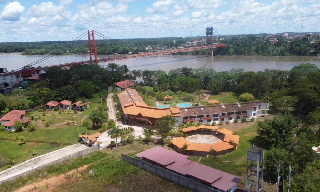 an aerial view of a building with a bridge in the background at Tantiri River Resort in Puerto Maldonado