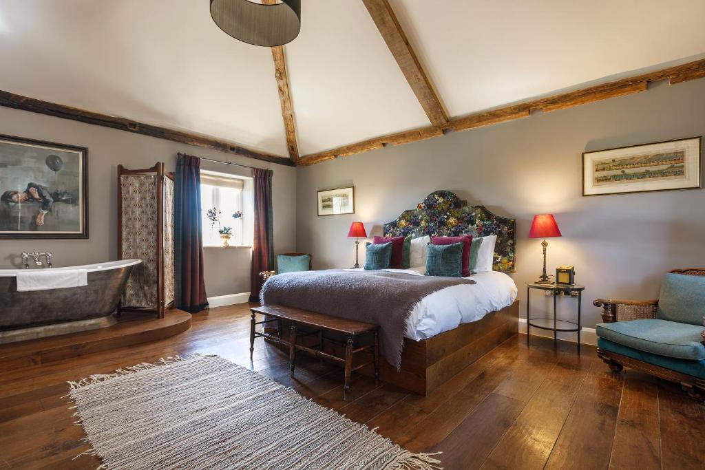 a bedroom with a bed and a tub in a room at The Brisley Bell in Brisley