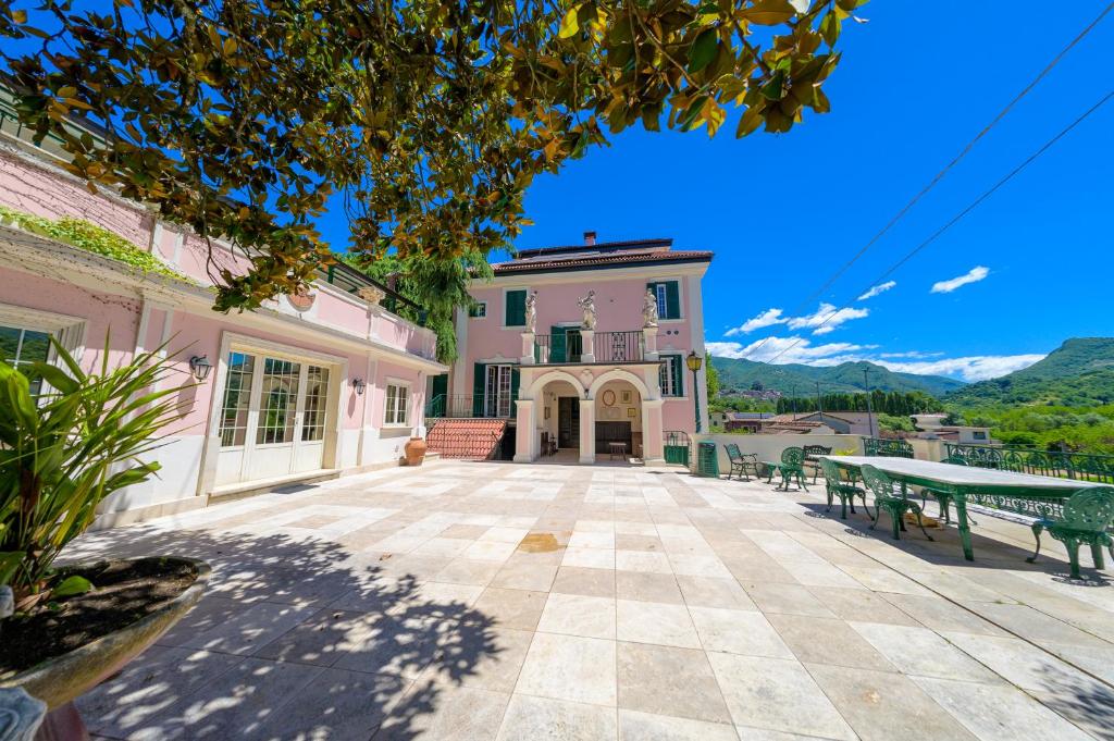 a large building with a patio with benches in front of it at Villa dei Papi Subiaco in Subiaco